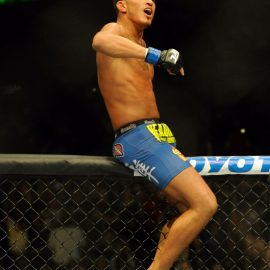 Anthony Pettis celebrates his UFC 164 victory over Benson Henderson on top of the cage