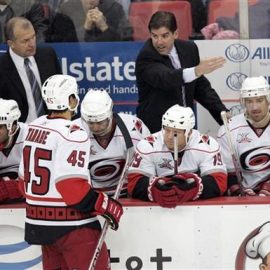 Carolina Hurricanes head coach Peter Laviolette talks to David Tanabe during a break in the third period of their NHL hockey game against the Detroit Red Wings at Joe Louis Arena in Detroit