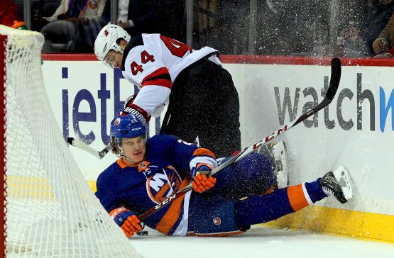 Jan 16, 2018; Brooklyn, NY, USA; New Jersey Devils left wing Miles Wood (44) and New York Islanders defenseman Sebastian Aho (28) collide at the boards during the first period at Barclays Center. Mandatory Credit: Andy Marlin-USA TODAY Sports