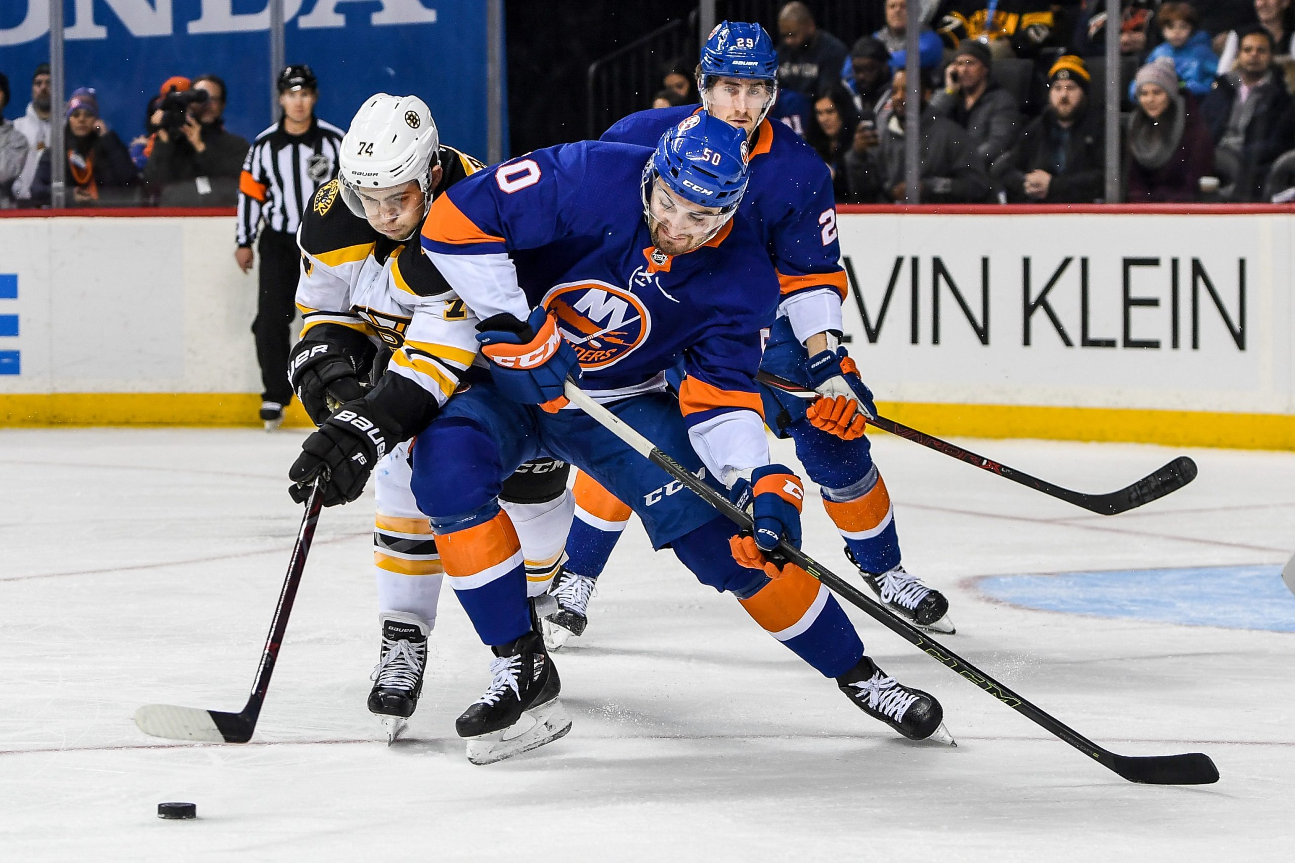 Jan 18, 2018; Brooklyn, NY, USA; New York Islanders defenseman Adam Pelech (50) and Boston Bruins left wing Jake DeBrusk (74) battle for the puck during the first period at the Barclays Center. Mandatory Credit: Dennis Schneidler-USA TODAY Sports