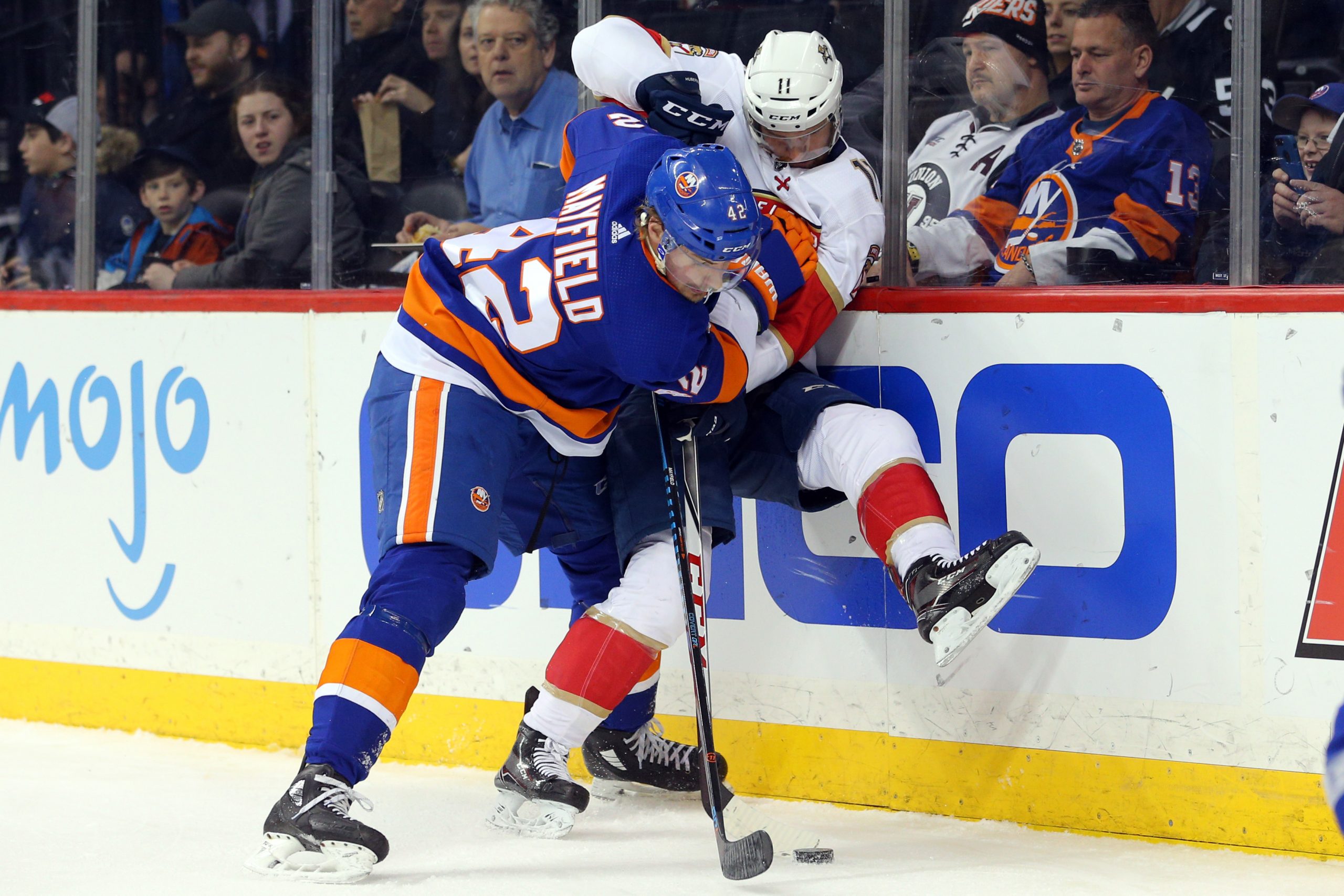 Jan 30, 2018; Brooklyn, NY, USA; New York Islanders defenseman Scott Mayfield (42) hits Florida Panthers center Jonathan Huberdeau (11) as they fight for the puck during the first period at Barclays Center. Mandatory Credit: Brad Penner-USA TODAY Sports