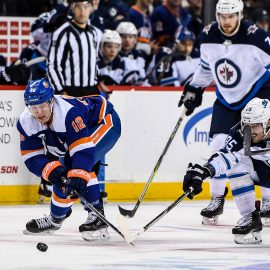 Dec 4, 2018; Brooklyn, NY, USA; New York Islanders right wing Josh Bailey (12) and Winnipeg Jets left wing Mathieu Perreault (85) reach for the puck during the third period at Barclays Center. Mandatory Credit: Dennis Schneidler-USA TODAY Sports