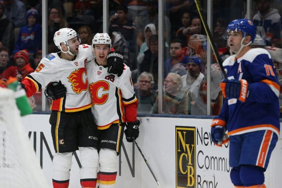Feb 26, 2019; Uniondale, NY, USA; Calgary Flames center Mikael Backlund (11) celebrates with Calgary Flames defenseman Mark Giordano (5) in front of New York Islanders right wing Cal Clutterbuck (15) after scoring a goal during the third period at Nassau Veterans Memorial Coliseum. Mandatory Credit: Brad Penner-USA TODAY Sports