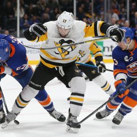 Dec 10, 2018; Uniondale, NY, USA; New York Islanders left wing Anders Lee (27) and New York Islanders center Mathew Barzal (13) fight for the puck with Pittsburgh Penguins right wing Bryan Rust (17) during overtime at Nassau Veterans Memorial Coliseum. Mandatory Credit: Brad Penner-USA TODAY Sports