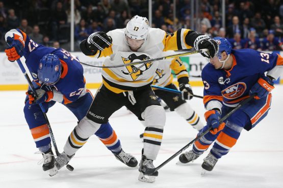 Dec 10, 2018; Uniondale, NY, USA; New York Islanders left wing Anders Lee (27) and New York Islanders center Mathew Barzal (13) fight for the puck with Pittsburgh Penguins right wing Bryan Rust (17) during overtime at Nassau Veterans Memorial Coliseum. Mandatory Credit: Brad Penner-USA TODAY Sports
