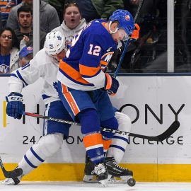 Apr 1, 2019; Uniondale, NY, USA; Toronto Maple Leafs center John Tavares (91) and New York Islanders right wing Josh Bailey (12) battle for the puck on the boards during the second period at Nassau Veterans Memorial Coliseum. Mandatory Credit: Dennis Schneidler-USA TODAY Sports