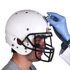 A football player wearing a helmet with doctors hand holding a s