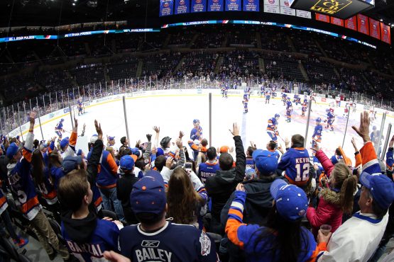 Dec 1, 2018; Uniondale, NY, USA; New York Islanders right wing Cal Clutterbuck (15) tosses a puck to fans during warmups before a game against the Columbus Blue Jackets at Nassau Veterans Memorial Coliseum. Mandatory Credit: Brad Penner-USA TODAY Sports