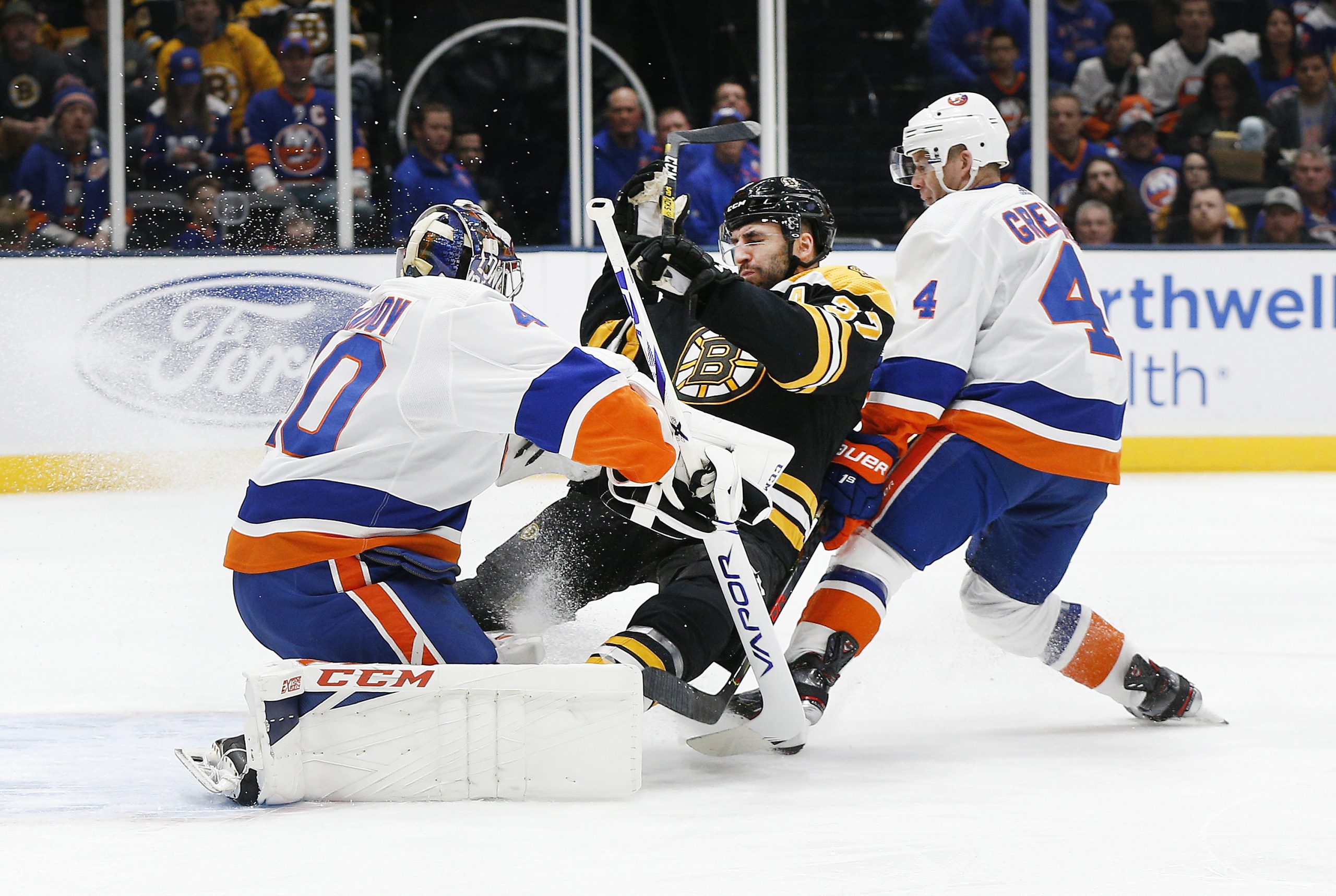 Feb 29, 2020; Uniondale, New York, USA; Boston Bruins center Patrice Bergeron (37) collides with New York Islanders goaltender Semyon Varlamov (40) during the first period at Nassau Veterans Memorial Coliseum. Mandatory Credit: Andy Marlin-USA TODAY Sports