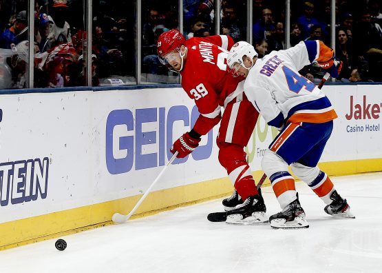 Feb 21, 2020; Uniondale, New York, USA; Detroit Red Wings right wing Anthony Mantha (39) and New York Islanders defenseman Andy Greene (4) battle for a loose puck during the first period at Nassau Veterans Memorial Coliseum. Mandatory Credit: Andy Marlin-USA TODAY Sports