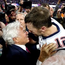 Robert Kraft and Tom Brady embrace and hug.
