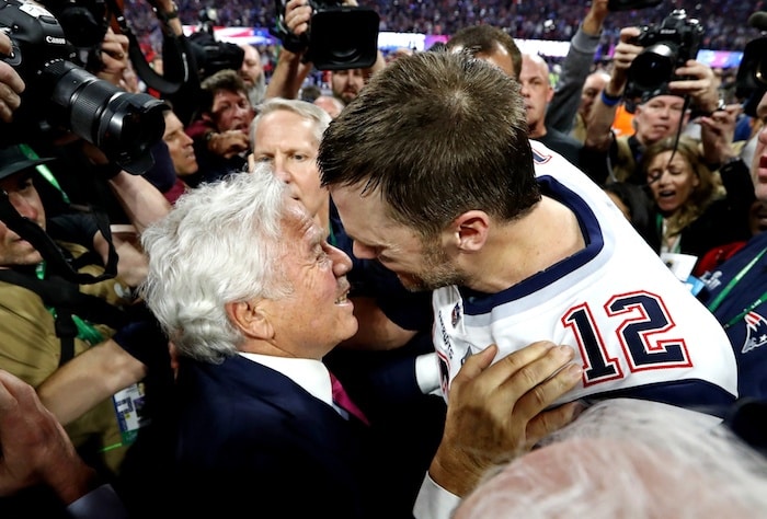 Robert Kraft and Tom Brady embrace and hug.