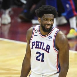 Philadelphia 76ers center Joel Embiid stands and smiles.