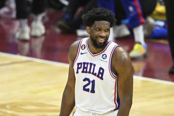 Philadelphia 76ers center Joel Embiid stands and smiles.