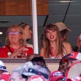 Taylor Swift reacts while sitting next to Donna Kelce